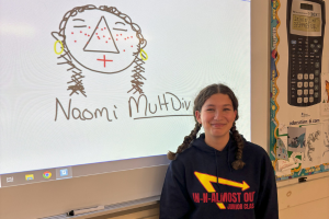  student posing in front of her math artwork